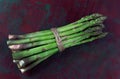 Close-up of a fresh raw asparagus bunch tied with a burlap twine isolated old wooden background. Royalty Free Stock Photo