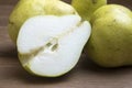 Whole and sliced green pears on wooden board Royalty Free Stock Photo