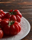 Close--up of Fresh red tomatoes raf, on white plate on wooden background. Food concept Royalty Free Stock Photo