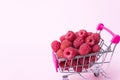 Close up fresh ripe raspberries in supermarket trolley, healthy eating concept, food background with summer berries