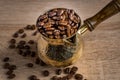 Close up of fresh roasted coffe beans in  cezve traditional turkish coffee pot on wooden table Royalty Free Stock Photo