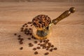 Close up of fresh roasted coffe beans in  cezve traditional turkish coffee pot on wooden table Royalty Free Stock Photo