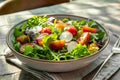 Close-up of fresh salad in bowl by napkin and fork on tiled floor