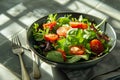 Close-up of fresh salad in bowl by napkin and fork on tiled floor