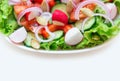 Close-up of a fresh salad of cucumbers, tomatoes, radishes, onions and other vegetables on a plate for a healthy meal Royalty Free Stock Photo