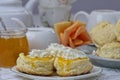 Close up of fresh scones topped apricot jam and whipped cream