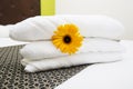 Close up a fresh towel with yellow flower on the bed Royalty Free Stock Photo