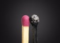 Close-up of a fresh unused matchstick close to a burnt one on a black background Royalty Free Stock Photo