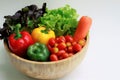 Close up of fresh vegetables in a wooden bowl, green oak, red oak, carrot, bell peppers, Cherry tomatoes Royalty Free Stock Photo