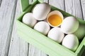 Close-up of fresh white organic chicken eggs and egg yolk in the green wooden box on light wooden background Royalty Free Stock Photo