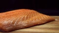 Close up for fresh, yummy salmon steak on wooden cutting board, isolated on black background. Raw red fish fillet on Royalty Free Stock Photo