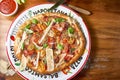 Close-up of a freshly-baked pizza on a plate, set on a wooden table Royalty Free Stock Photo