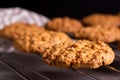 Close-up of a freshly baked stack of warm oatmeal cookies on a cooling rack on a dark background