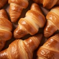 Close-up of freshly baked tasty croissants as background, placed in rows on a black tray. Food concept. Warm Fresh Buttery