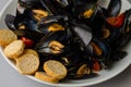 Close up of freshly cooked mussels with crisp bread and tomato. Healthy food concept. Selective focus Royalty Free Stock Photo