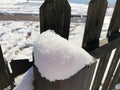 Close up of freshly fallen snow on top of a wooden fence post Royalty Free Stock Photo