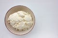 Close-up of freshly made white soft cottage cheese in bowl on white table background. Homemade ricotta cheese. Royalty Free Stock Photo
