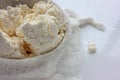 Close-up of freshly made white soft cottage cheese in bowl on white table background. Homemade ricotta in cheesecloth. Royalty Free Stock Photo