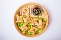 Close up fried dim sum and sauce in bamboo steamer on the white background isolated. Chinese cuisine. Selective focus, top view. Royalty Free Stock Photo