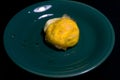 A close-up of fried eggs is located on a small green plate on a black background Royalty Free Stock Photo