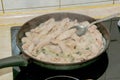 Close-up of fried pork pieces in the process of frying in a pan