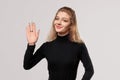 Close up blonde girl is saluting with hand with happy expression, showing five fingers, friendly welcome gesture