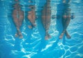 Friends, family legs underwater in the swimming pool with copy space