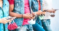 Close up of friends hands with face masks using tracking app on mobile smart phones - Young millenial people sharing content Royalty Free Stock Photo