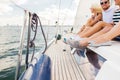 Close up of friends legs sitting on yacht deck