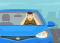 Close-up of a frightened male driver holding his head with hands while driving. Front view of a car on city road. Royalty Free Stock Photo