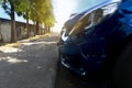 Close up front of dark blue color car. Parking beside of footpath concreate with blurre of other cars. Royalty Free Stock Photo