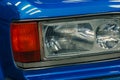 Close-up of front halogen headlights of blue car in garage