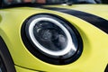 Close up of front headlight of bright yellow Mini Cooper S Cabriolet Convertible. Vehicle exterior led lights on Royalty Free Stock Photo