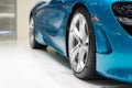 Close up front of new blue car with Magnesium alloy wheel parking on car showroom. Dealership office or retail shop and technology Royalty Free Stock Photo