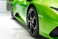 Close up front of new green car with Magnesium alloy wheel parking on car showroom. Dealership office or retail shop and