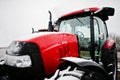 Close up in front of the new red tractor at snowy weather Royalty Free Stock Photo