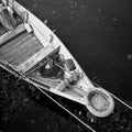 Close-up of front side of small fisherman boat moored in port. Small row boat floating. Black and white photography.