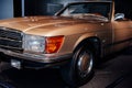 Close-up of front and side view of the left headlight with a turn sign of retro beige cabriolet car with chrome radiator Royalty Free Stock Photo