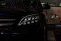 Close up, front side view of left led headlight and chrome radiator grille of the modern deep blue sport car with Royalty Free Stock Photo