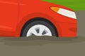 Close-up of front tire of a red car which got stuck on a muddy road. Side view of a front tire. Royalty Free Stock Photo