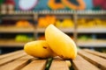 Close-up front view of fresh juicy pineapple standing on wooden pallet at fruit and vegetables section of grocery store. Royalty Free Stock Photo