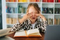 Close-up front view of frustrated exhausted primary child school girl rubbing tired from active reading eyes, doing lots Royalty Free Stock Photo