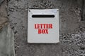 A metal Letter box (post box) mounted on a concrete wall, in front of a house Royalty Free Stock Photo