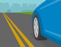 Close-up of front wheel of blue car on a highway. Yellow double solid road line. Royalty Free Stock Photo