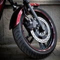 Close-up front wheel and fork of a modern beautiful motorcycle parked in the city street