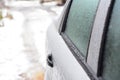 A close-up of a frozen car door, car window covered with ice. Unfreezing, de-icing the car door properly to open frozen car locks Royalty Free Stock Photo