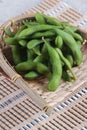 Close-up frozen edamame beans in the basket on makisu meal mat ready to serve at Japanese restaurant in Bangkok, Thailand