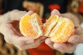 Close up of fruit,old elderly holding juicy orange in hands,senior woman showing peeled tangerine,eat vitamin C from orange fiber,