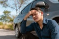 Close up Frustrated man sitting near his broken car on the country road. Driver waiting for the insurance service. Broken car conc Royalty Free Stock Photo