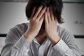 Close up frustrated stressed young Asian business man with hands covering face and feeling disappointed or exhausted with job.